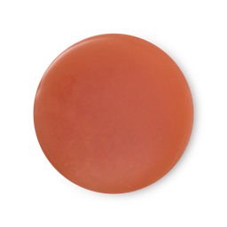 An arial view of deep, vibrant orange, balm-like Karma solid perfume.